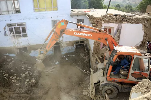 An excavator removes mud from a damaged house after heavy flooding in the Maidan Wardak province in the central of Afghanistan, Sunday, July 23, 2023. Heavy flooding from seasonal rains in Afghanistan killed multiple people and left dozens missing over the past three days. (AP Photo)