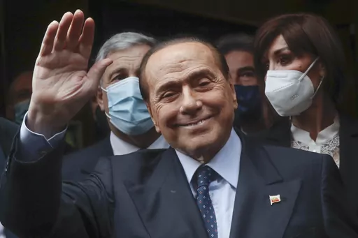 Former Italian Premier Silvio Berlusconi waves to reporters as he arrives at the Chamber of Deputies to meet Mario Draghi, in Rome, Feb. 9, 2021. Berlusconi, the boastful billionaire media mogul who was Italy's longest-serving premier despite scandals over his sex-fueled parties and allegations of corruption, died, according to Italian media. He was 86. (AP Photo/Alessandra Tarantino, File)