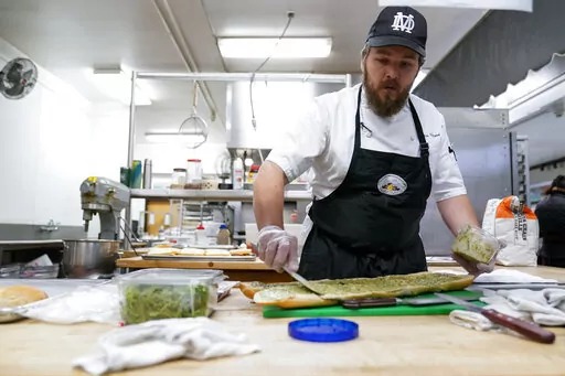 Chef Josh Gjersand prepares a sandwich for Mount Diablo High School students to try during a taste test in Concord, Calif., Friday, Jan. 13, 2023. The school district in suburban San Francisco has been part of a national "farm-to-school" movement for years, where schools try to buy as much locally as possible. But the mission has been kicked into higher gear with a California program that provides free meals to all public school students in the state, along with unprecedented new funding. (AP Ph