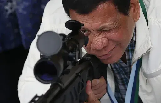Philippine President Rodrigo Duterte checks the scope of a Chinese-made CS/LR4A sniper rifle during the presentation of thousands of rifles and ammunition by China to the Philippines at Clark Airbase in northern Philippines on June 28, 2017. (AP Photo/Bullit Marquez, File)