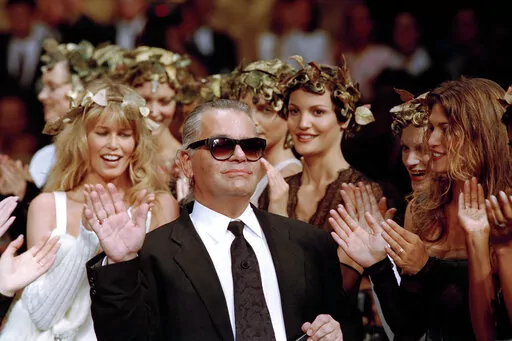 German fashion designer Karl Lagerfeld acknowledges the applause of his models at the end of the show he designed for the French fashion house Chanel, for the 1993-94 Fall-Winter haute couture collection in Paris, July 20, 1993. US Vogue Editor-in-Chief Anna Wintour convened a huddle of top Paris Fashion Week insiders Friday to announce that the theme of next year's annual Met Gala will be the work of the late Karl Lagerfeld. (AP Photo/Lionel Cironneau, File)