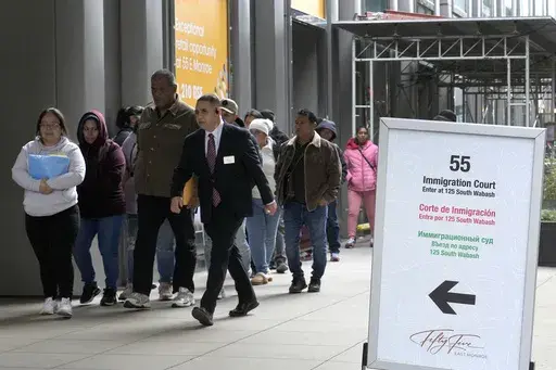 After waiting in a cue, people are led into a downtown Chicago building where an immigration court presides, Nov. 12, 2024, in Chicago. (AP Photo/Charles Rex Arbogast, File)