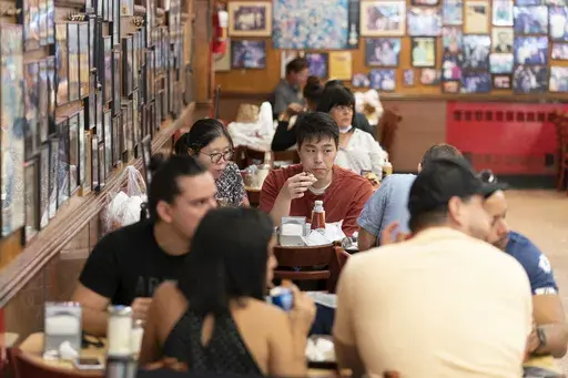 Customers have lunch at Katz's Delicatessen on Sept. 30, 2020 in New York. In a recent column, New York Times restaurant critic Pete Wells announced he's leaving the beat because the constant eating has led to obesity and other health problems. (AP Photo/Mary Altaffer, File)