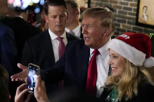Former President Donald Trump greets supporters during a stop at the Front Street Pub & Eatery, Tuesday, Dec. 5, 2023, in Davenport, Iowa. (AP Photo/Charlie Neibergall)