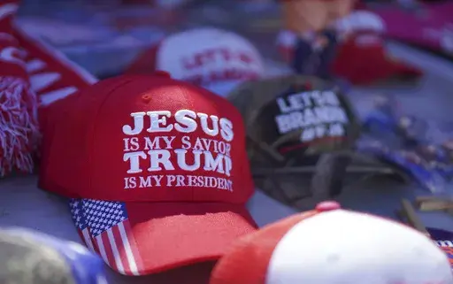 Hats reading a variety of slogans including, "Jesus is my savior, Trump is my president," are sold at a campaign rally for former President Donald Trump in Vandalia, Ohio, March 16, 2024. (AP Photo/Jessie Wardarski, File)
