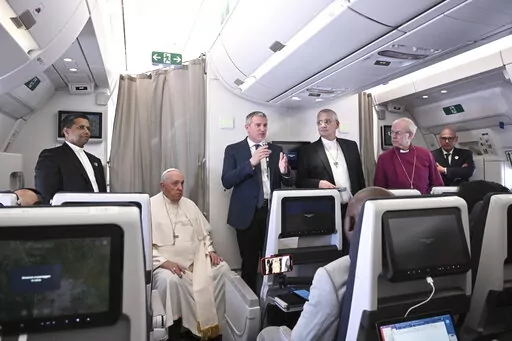 The Archbishop of Canterbury Justin Welby, right, Pope Francis,left, and the Moderator of the General Assembly of the Church of Scotland Iain Greenshields meet the journalists during an airborne press conference aboard the airplane directed to Rome, at the end of his pastoral visit to Congo and South Sudan, Sunday, Feb. 5, 2023. (Tiziana Fabi/Pool Photo Via AP)