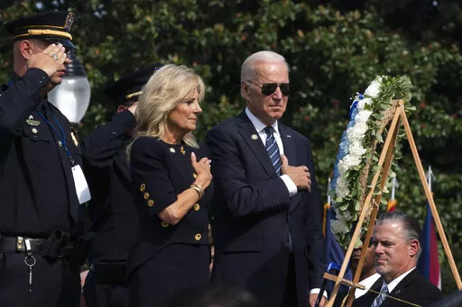 President Joe Biden and first lady Jill Biden put their right hand over their heart after placing flowers on a wreath during a ceremony honoring fallen law enforcement officers at the 40th annual National Peace Officers' Memorial Service at the U.S. Capitol in Washington, Oct. 16, 2021. Saluting on the left is James Smallwood, National Treasurer of the National Fraternal Order of Police. (AP Photo/Manuel Balce Ceneta, File)