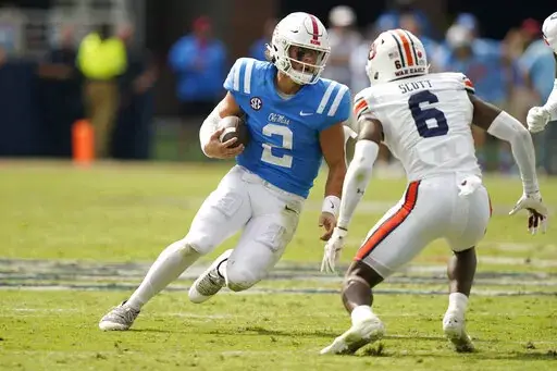 Mississippi quarterback Jaxson Dart (2) tries to evade a tackle attempt by Auburn cornerback Keionte Scott (6) during the second half of an NCAA college football game in Oxford, Miss., Saturday, Oct. 15, 2022. Mississippi won 48-34. (AP Photo/Rogelio V. Solis)