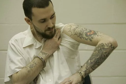 Inmate Michael Tisius, sentenced to death in the killing of two jail officers, shows his tattoos during an interview at Potosi Correctional Center, Missouri's maximum security prison where condemned men live in the general prison population in Mineral Point, Mo., on Jan. 11, 2007. A federal judge on Wednesday, May 31, 2023, halted next week's scheduled execution of Tisius, a man convicted of killing two Missouri jailers, amid questions about the literacy of a juror in the case. (AP Photo/Jeff Ro
