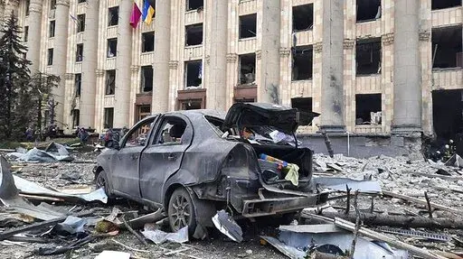 In this handout photo released by Ukrainian Emergency Service, a burnt car is seen in front of a damaged City Hall building, in Kharkiv, Ukraine, Tuesday, March 1, 2022. Russian shelling pounded civilian targets in Ukraine's second-largest city, Kharkiv, Tuesday and a 40-mile convoy of tanks and other vehicles threatened the capital - tactics Ukraine's embattled president said were designed to force him into concessions in Europe's largest ground war in generations. (Ukrainian Emergency Service 