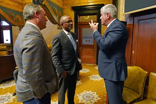 Rep. Robert Johnson, D-Natchez, center, confers with House Speaker Philip Gunn, R-Clinton, right, and House Speaker Pro Tempore Jason White, R-West, during a break, in chamber, Monday, March 28, 2022, at the Mississippi Capitol in Jackson. (AP Photo/Rogelio V. Solis)