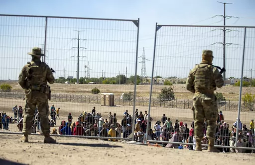 Migrants wait in line adjacent to the border fence under the watch of the Texas National Guard to enter into El Paso, Texas, Wednesday, May 10, 2023. U.S. authorities say an 8-year-old girl died Wednesday, May 17, in Border Patrol custody, a rare occurrence that comes as the agency struggles with overcrowding. The Border Patrol had 28,717 people in custody on May 10, the day before pandemic-related asylum restrictions expired, which was double from two weeks earlier, according to a court filing.