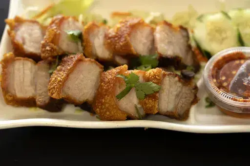 Crispy Pork Belly is presented at "Love & Thai" restaurant in Fresno, Calif., on Dec. 20, 2023. The Thai restaurant was wrongfully accused of abusing a dog to turn it into meat, a false claim rooted in a racist stereotype. (AP Photo/Richard Vogel, File)