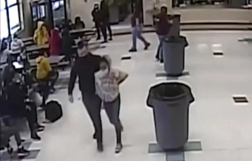 In this frame grab from surveillance video provided by the Kenosha Unified School District, an off-duty police officer escorts a 12-year-old student out of a school cafeteria following a lunchtime fight, in Kenosha, Wis., on March 4, 2022. Earlier in the video, the officer, who was working as a security guard, is shown intervening in the fight and putting his knee on the girl’s neck to restrain her. (Kenosha Unified School District via AP)