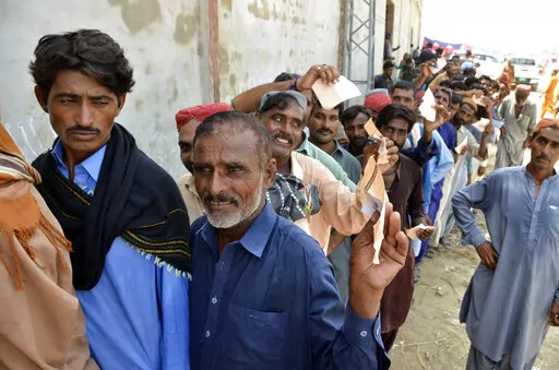 Displaced families, who fled their flood-hit homes, line up to get relief aid in Jaffarabad, a district of Baluchistan province, Pakistan, Wednesday, Sept. 21, 2022. Devastating floods in Pakistan's worst-hit province have killed 10 more people in the past day, including four children, officials said Wednesday as the U.N. children's agency renewed its appeal for $39 million to help the most vulnerable flood victims. (AP Photo/Zahid Hussain)
