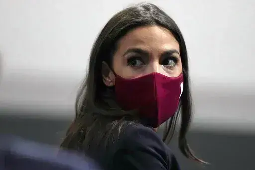 U.S. Rep. Alexandria Ocasio-Cortez looks round to listen to a question at the COP26 U.N. Climate Summit, in Glasgow, Scotland, Wednesday, Nov. 10, 2021. Ocasio-Cortez has tested positive for COVID-19 and “is experiencing symptoms and recovering at home,” her office said in a statement Sunday, Jan. 9, 2022. (AP Photo/Alastair Grant, File)