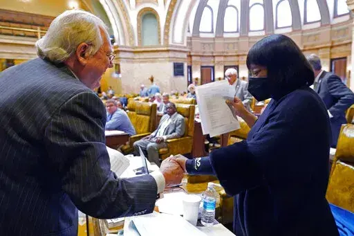 House Appropriations Committee Chairman John Read, R-Gautier, left, assures Rep. Omeria Scott, D-Laurel, that she would be receiving an updated grid of the total state support for agencies for fiscal year 2023, in the House chamber at the Mississippi Capitol in Jackson, Miss., Monday, April 4, 2022. (AP Photo/Rogelio V. Solis)