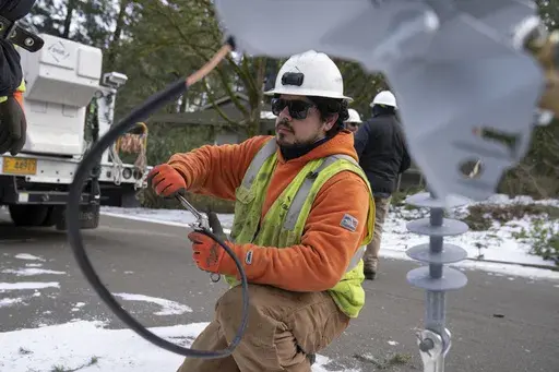 A worker from Portland General Electric replaces a power line as crews work to restore power after a storm on Jan. 16, 2024, in Lake Oswego, Ore. On Friday, Feb. 2, 2024, the U.S. government issues its January jobs report. (AP Photo/Jenny Kane, File)
