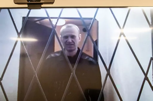 Russian opposition leader Alexei Navalny is seen on a TV screen as he appears in a video link provided by the Russian Federal Penitentiary Service from the courtroom in Kovrov, Vladimir region, about 240 kilometers (150 miles) east of Moscow, Russia, Wednesday, Jan. 10, 2024. Navalny, 47, is jailed on charges of extremism. He had been imprisoned in the Vladimir region of central Russia, but was transferred last month to a "special regime" penal colony — the highest security level of prisons in