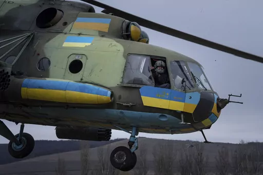 A Ukrainian pilot waves to his comrades from an Mi-8 combat helicopter during a combat mission in Donetsk region, Ukraine, Saturday, March 18, 2023. (AP Photo/Evgeniy Maloletka)