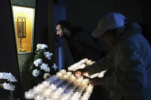 A man looks at the heart relic of Carlo Acutis, the 15-year-old Italian boy who died in 2006 of leukemia and beatified in 2020, at the San Rufino Cathedral in Assisi, Italy, Wednesday, April 2, 2025. (AP Photo/Alessandra Tarantino)