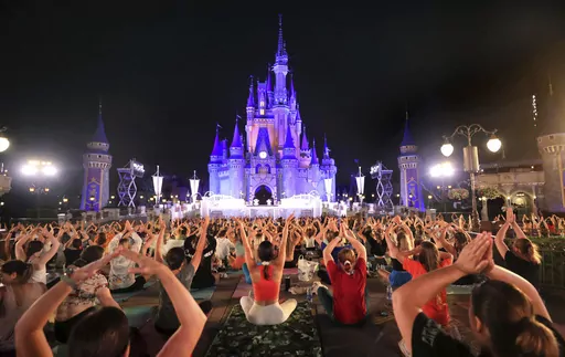 On the morning of the summer solstice, Walt Disney World cast members stretch at Cinderella Castle in the Magic Kingdom, in Lake Buena Vista, Fla., in a pre-dawn gathering before the park opened Wednesday, June 21, 2023, for their annual team yoga session to commemorate International Yoga Day. An estimated 2,000 employees participated in Wednesday's rain-shortened event, now in its 7th year at Disney World. The International Day of Yoga occurs worldwide each year on the summer solstice and was e
