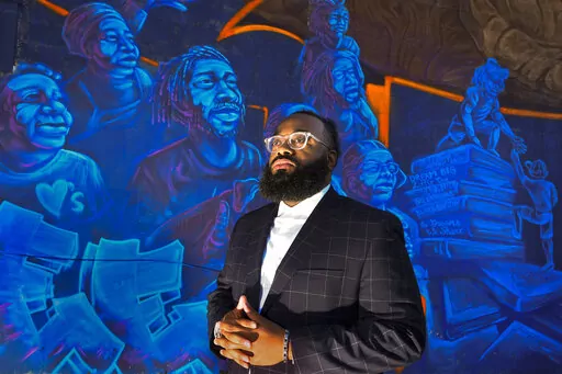 Pastor Aaron Marble stands in front of a mural in the historically black community of North Nashville, Friday, Feb.11, 2022, in Nashville, Tenn. The area is being combined into a mostly white congressional district, a move Marble believes will unfairly affect black voters. (AP Photo/John Amis)