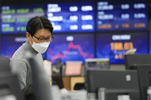 A currency trader watches monitors at the foreign exchange dealing room of the KEB Hana Bank headquarters in Seoul, South Korea, Friday, Feb. 11, 2022. Shares were mostly lower Friday in Asia after a sell-off on Wall Street spurred by news that U.S. inflation jumped 7.5% in January, which raised expectations the Federal Reserve will need to move forcefully to cool the economy by raising interest rates. (AP Photo/Ahn Young-joon)