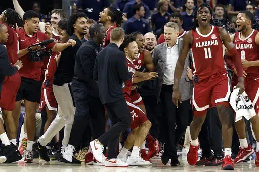 Alabama guard Mark Sears (1) celebrates with teammates and head coach Nate Oats after making a game-wining shot against Auburn in overtime of an NCAA college basketball game, Saturday, March 8, 2025, in Auburn, Ala. (AP Photo/Butch Dill)