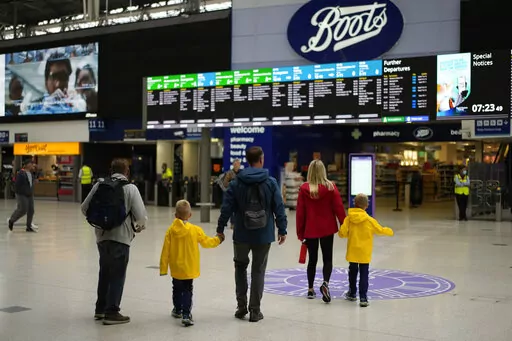 People look at departure screens at Waterloo train station, in London, during a railway workers strike, Thursday, June 23, 2022. Tens of thousands of railway workers walked off the job in Britain on Tuesday, bringing the train network to a crawl in the country's biggest transit strike for three decades. Britain faces the second of three national railway strikes Thursday after new negotiations between union and employers ended in deadlock. (AP Photo/Matt Dunham)