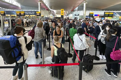 Travellers queue at security at Heathrow Airport in London, Wednesday, June 22, 2022. London’s Heathrow Airport  apologized Monday, July 11, 2022 to passengers whose travels have been disrupted by staff shortages. The airport warned that it may ask airlines to cut more flights from their summer schedules to reduce the strain if the chaos persists. (AP Photo/Frank Augstein, File)
